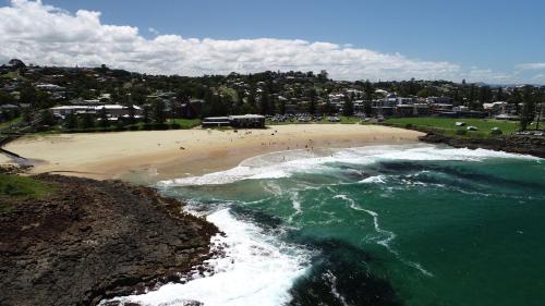 an aerial view of a beach with people in the water at Scandi Retreat - Central Kiama in Kiama