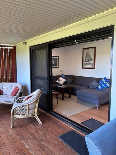 a living room with a couch and a table at Sandbar views in Smiths Lake