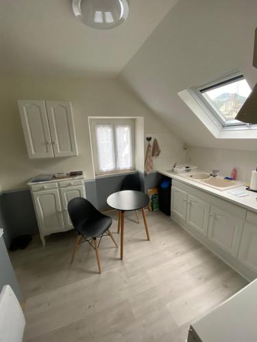 une cuisine avec une table et deux chaises ainsi qu'une fenêtre dans l'établissement PYRENE HOLIDAYS - Héraclès - Résidence paisible à 6mn à pied des thermes, à Bagnères-de-Bigorre
