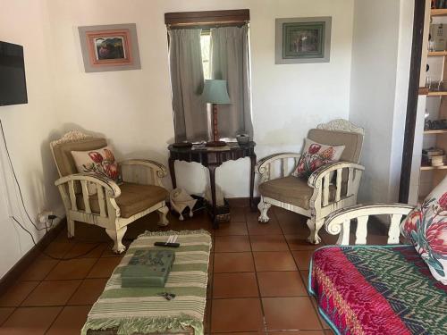 a living room with two chairs and a table at Aan de Bergen in Swellendam