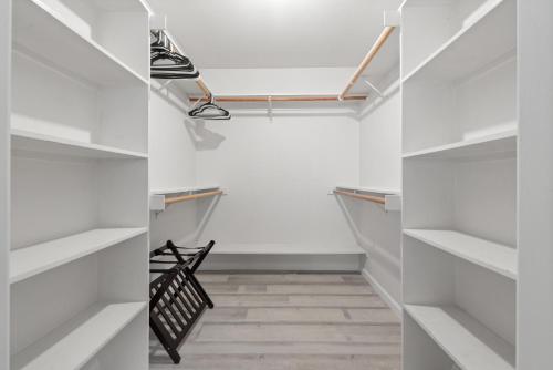 a walk in closet with white shelves and a staircase at Luxury Family Villa Sleeps 20 in Coarsegold