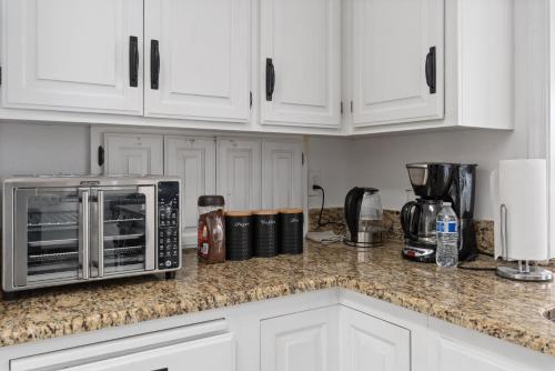 a kitchen with white cabinets and a microwave on a counter at Luxury Family Villa Sleeps 20 in Coarsegold