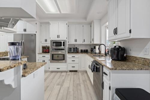 a white kitchen with white cabinets and stainless steel appliances at Luxury Family Villa Sleeps 20 in Coarsegold