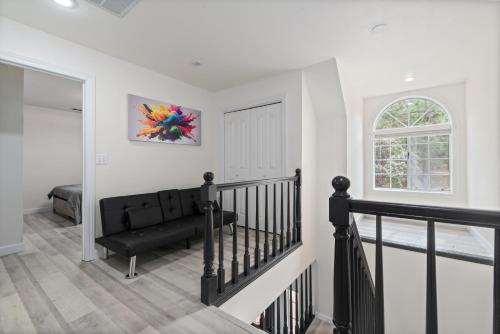 a living room with a black couch and a window at Luxury Family Villa Sleeps 20 in Coarsegold