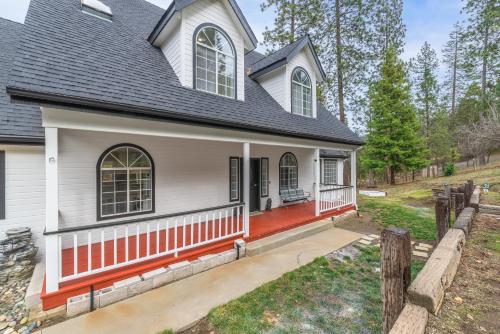 a white house with a red front porch at Luxury Family Villa Sleeps 20 in Coarsegold