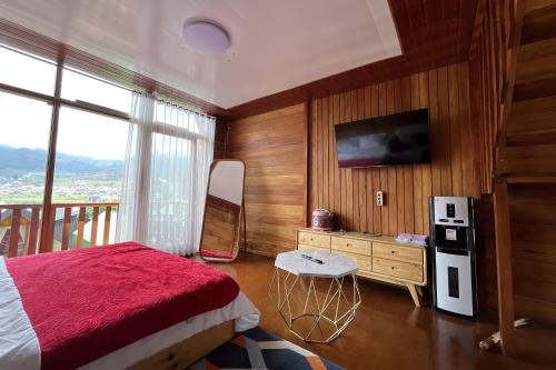 DiyengにあるSavana Cabin by Fifa Grupのベッドと壁にテレビが掛かった寝室