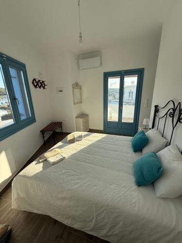 a bedroom with a large white bed with blue pillows at Boutique Village in Leipsoi