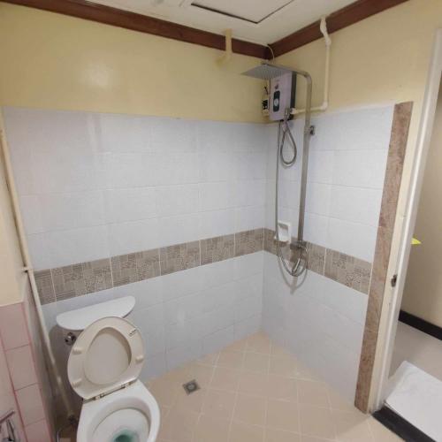 a bathroom with a toilet and a shower at Spring Plaza Hotel in Dasmariñas