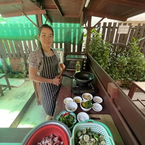 a woman standing next to a table with food at Old Khmer House in Siem Reap