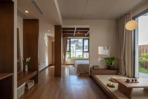 a living room with a large window and a bedroom at Dali Lark View Private Hot Spring Hotel in Dali