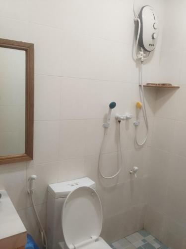 a bathroom with a shower with a toilet and a sink at Equatorial Inn in Feydhoo