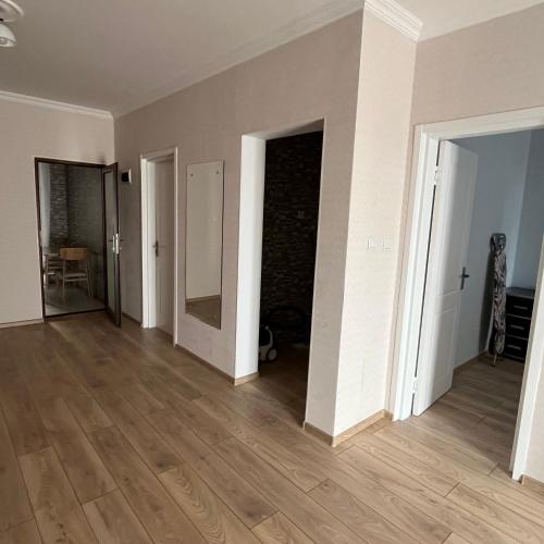 an empty room with white walls and wooden floors at Mika's Apartment in Tbilisi City