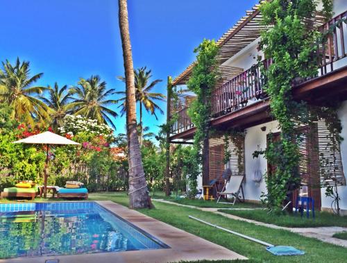 a backyard with a swimming pool and a house at Villa Albergaria in Flecheiras