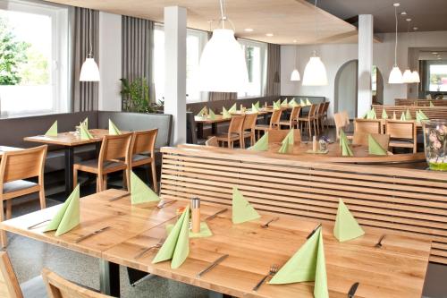 un restaurante con mesas y sillas de madera y papel verde en Hotel Waldhorn, en Friedrichshafen