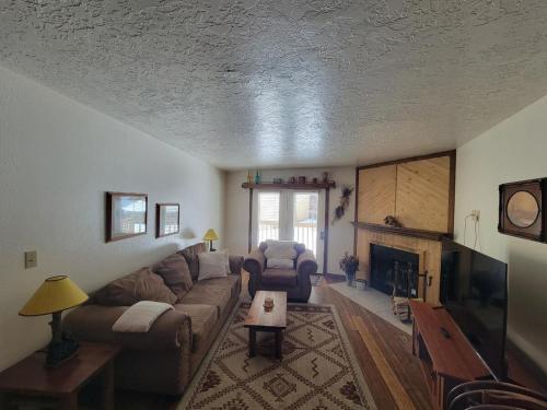 a living room with a couch and a fireplace at Cozy Retreat with Scenic Views- Prestige Vacations in Brian Head