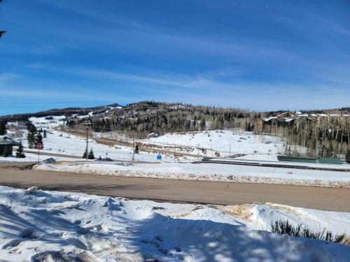 a snow covered road with a mountain in the background at Cozy Retreat with Scenic Views- Prestige Vacations in Brian Head