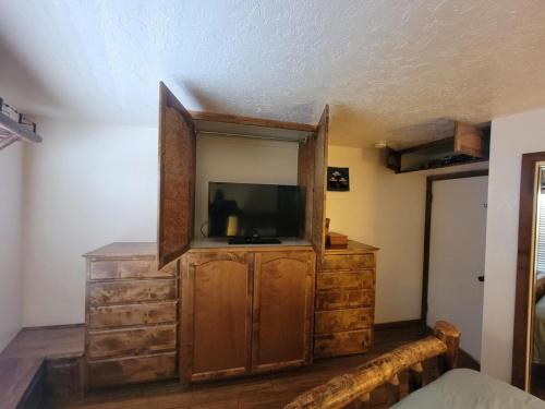 a bedroom with a tv and a dresser with a mirror at Cozy Retreat with Scenic Views- Prestige Vacations in Brian Head