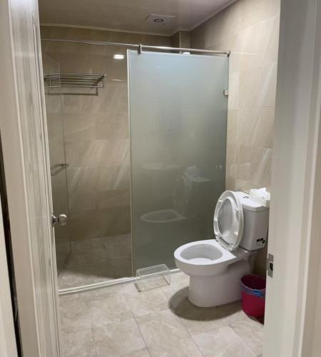 a bathroom with a toilet and a glass shower at 稼鄉旅宿 in Xizhou