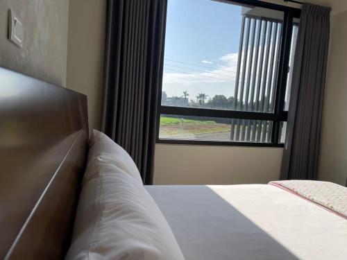 a bedroom with a bed and a large window at 稼鄉旅宿 in Xizhou