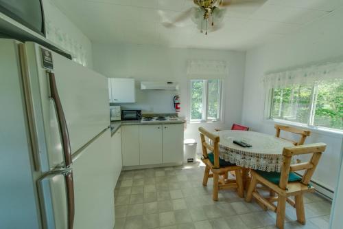 a kitchen with a table and chairs and a refrigerator at Chalet Au Bord du St-Maurice in La Tuque