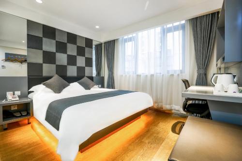 a hotel room with a bed and a desk at Zsmart智尚酒店上海南京西路梅陇镇广场店 in Shanghai