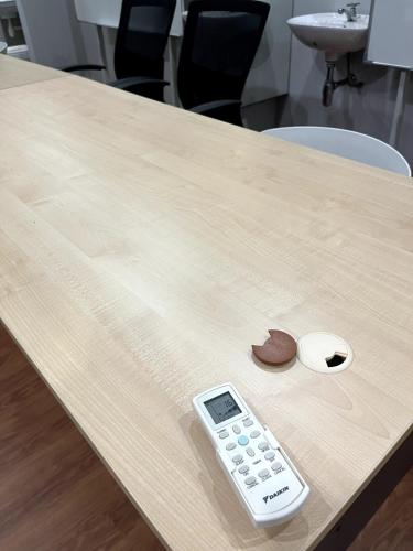 a remote control sitting on a table with a calculator at JZ at Bandar Baru Klang Townhouse in Klang