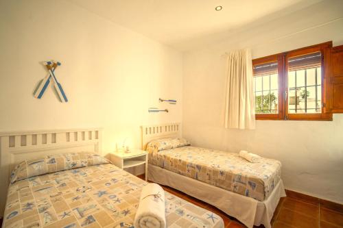 een slaapkamer met twee bedden en een raam bij Casa ZAHOMAR con piscina exterior in Zahora