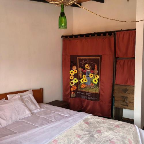 a bedroom with a bed and a curtain with sunflowers at Posada María E in Mucuchíes