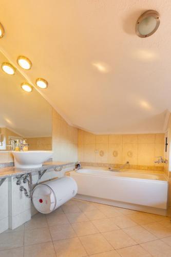 a large bathroom with a tub and a sink at Downtown Bansko Resort in Bansko
