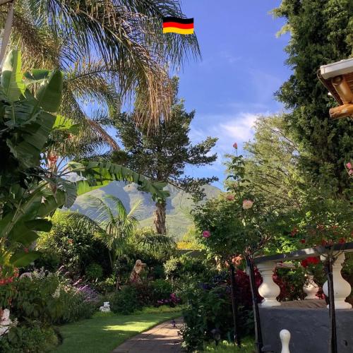 a garden with a flag flying in the sky at Bollinger Guest House in George
