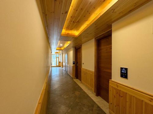 a hallway with wooden ceilings and a long corridor at CHAMBYAL's RETREAT in Manāli