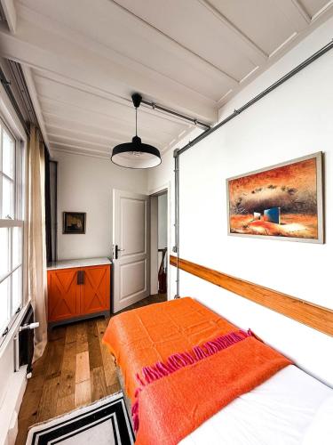 a bedroom with a bed with an orange blanket at Rent the Entire Bosphorus House in Istanbul