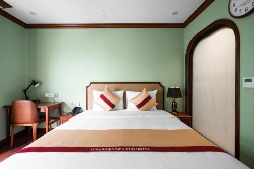 a bedroom with a large bed with a clock on the wall at 12 A&B Điện Biên Phủ Hà Nội Hotel in Hanoi