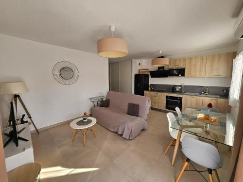 un salon avec un canapé et une table en verre dans l'établissement Appartement cosy à Lucciana, 56 m², vue montagne, à Lucciana