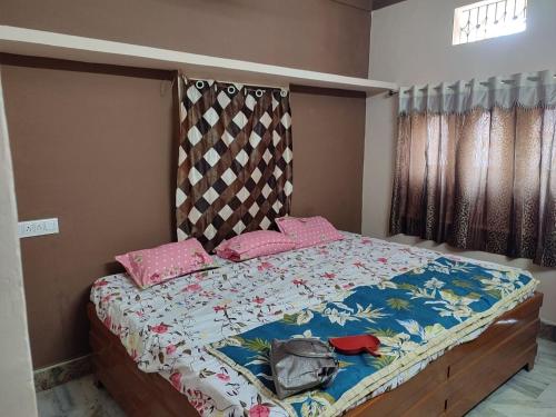 a bedroom with a bed with pink pillows at Tirth HomeStay in Ujjain