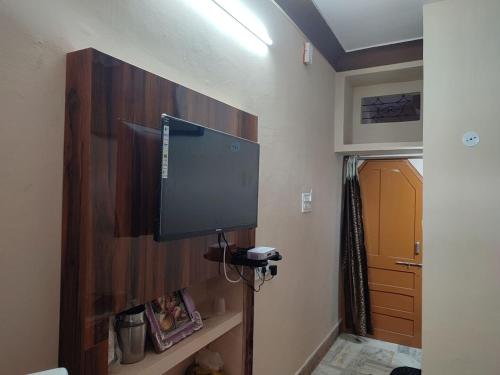a flat screen tv on the wall of a room at Tirth HomeStay in Ujjain