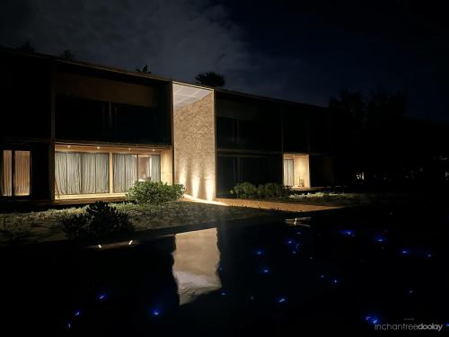 a building with a pool in front of it at night at inchantreedoolay huahin in Pran Buri