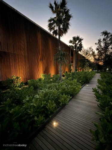 a walkway with lights in front of a building at inchantreedoolay huahin in Pran Buri