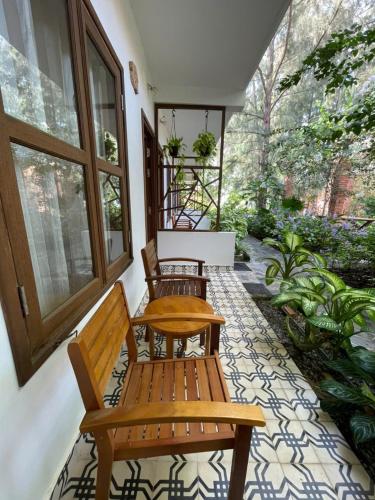 two wooden benches sitting on the porch of a house at Nhà Gỗ An Nhiên in Xóm Chum Găng