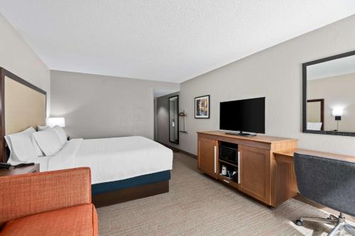 a hotel room with a bed and a flat screen tv at Hampton Inn Debary-Deltona in DeBary
