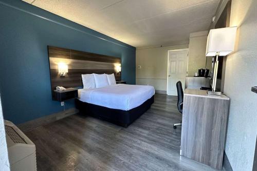 a hotel room with a bed and a desk at Days Inn by Wyndham San Diego Vista in Vista