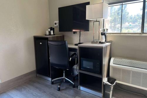 a room with a desk with a computer and a chair at Days Inn by Wyndham San Diego Vista in Vista