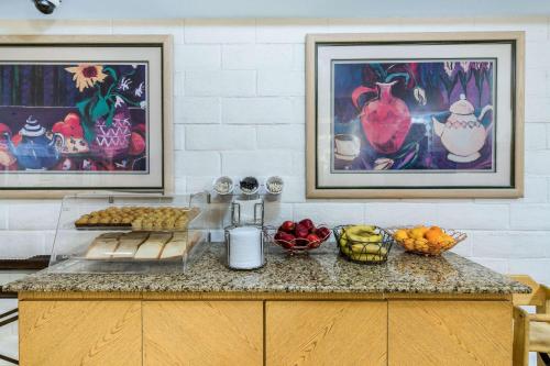 a kitchen counter with fruit on it with two pictures at Days Inn by Wyndham San Diego Vista in Vista
