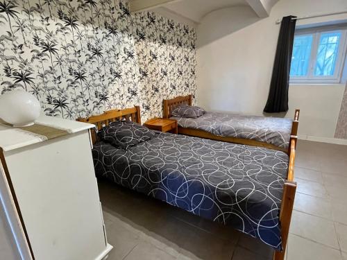 une chambre avec deux lits dans une pièce dans l'établissement Joli logement proche du Mont Lozère, à La Vernarède