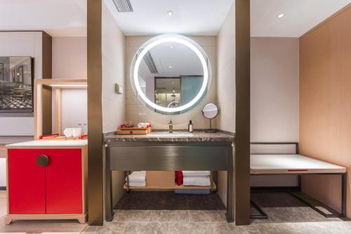 a bathroom with a sink and a mirror at Madison Hotel, Qingdao Laoshan Polar Ocean Park in Qingdao