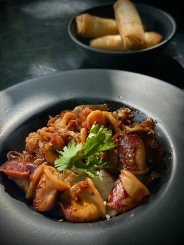 a plate of food with meat and a garnishment at inchantreedoolay huahin in Pran Buri
