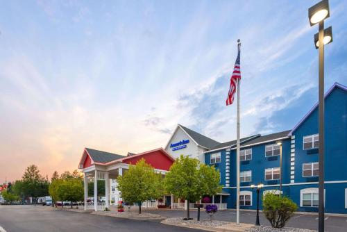 a hotel with an american flag on a street at AmericInn by Wyndham Iron Mountain in Iron Mountain