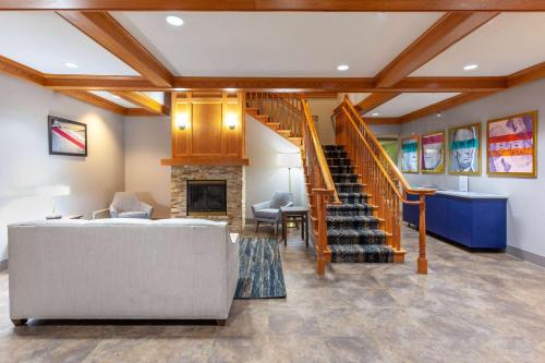 a living room with a staircase and a couch at AmericInn by Wyndham Iron Mountain in Iron Mountain