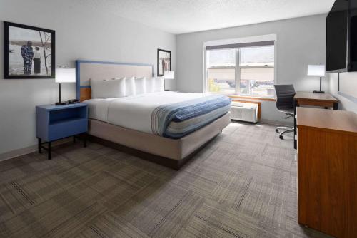 a hotel room with a bed and a desk and a window at AmericInn by Wyndham Iron Mountain in Iron Mountain
