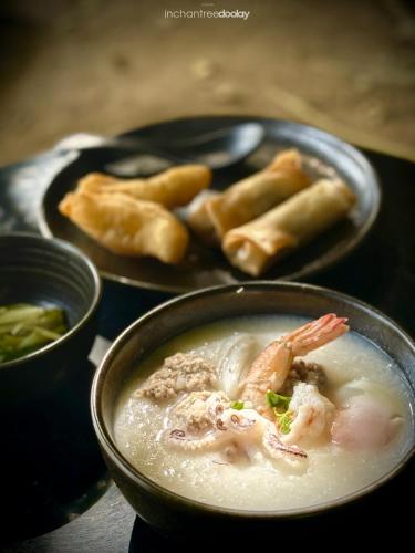 a bowl of soup and a plate of food at inchantreedoolay huahin in Pran Buri